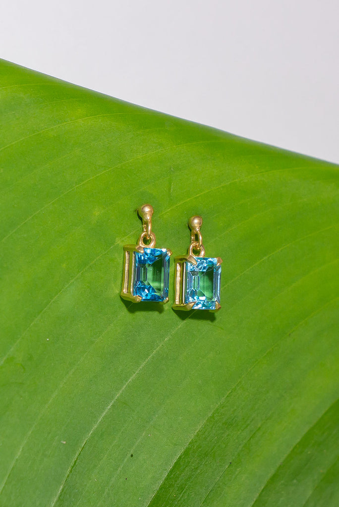 These pretty ocean coloured blue Topaz earrings are a perfect droplet of sea and sky. Pretty earrings with an emerald cut Blue Topaz gemstone set in 9ct gold vermeil. Made exclusively for Mombasa Rose Boutique.