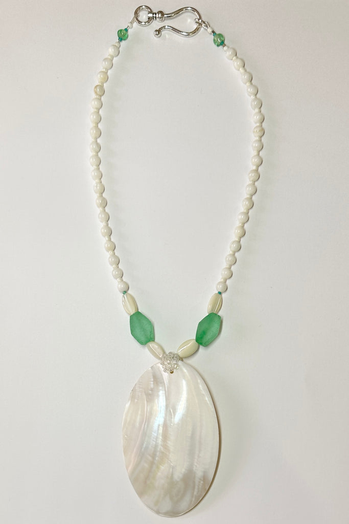 This wonderful Pearly Seas necklace has been designed to use pieces from many countries, the centre piece is a magical slice of mother of pearl shell which has a resin backing, the sea green  side beads are recycled glass from Nigeria in Africa, the pearl shell beads are from The Philippines.