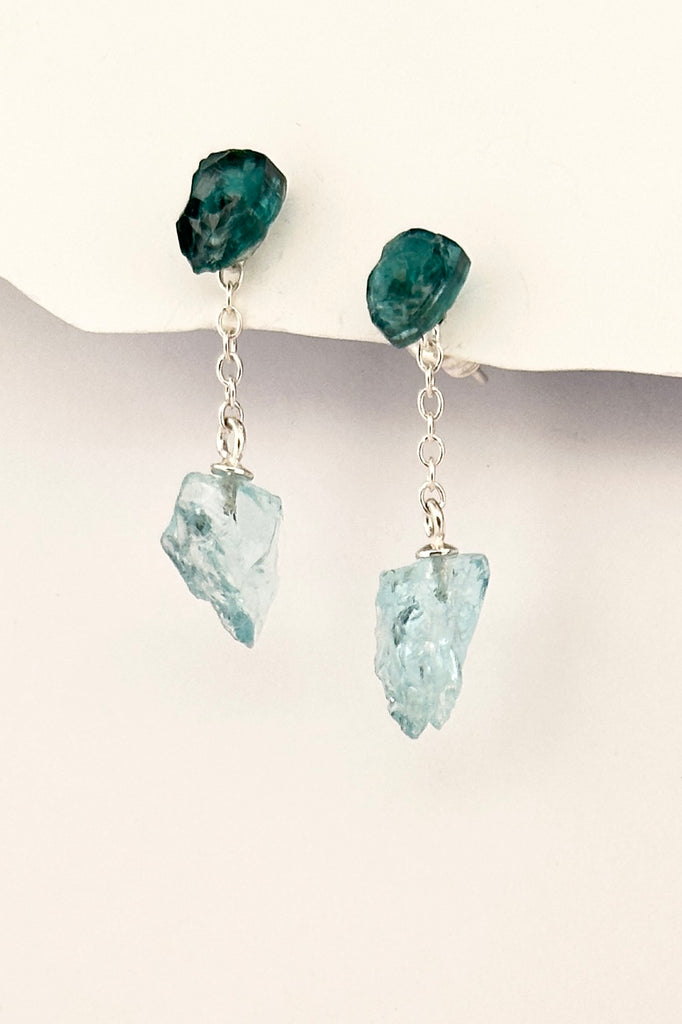 One off earrings made by hanging a natural crystal of natural Aquamarine off a tiny chain, the stud is a shard of teal green Tourmaline.