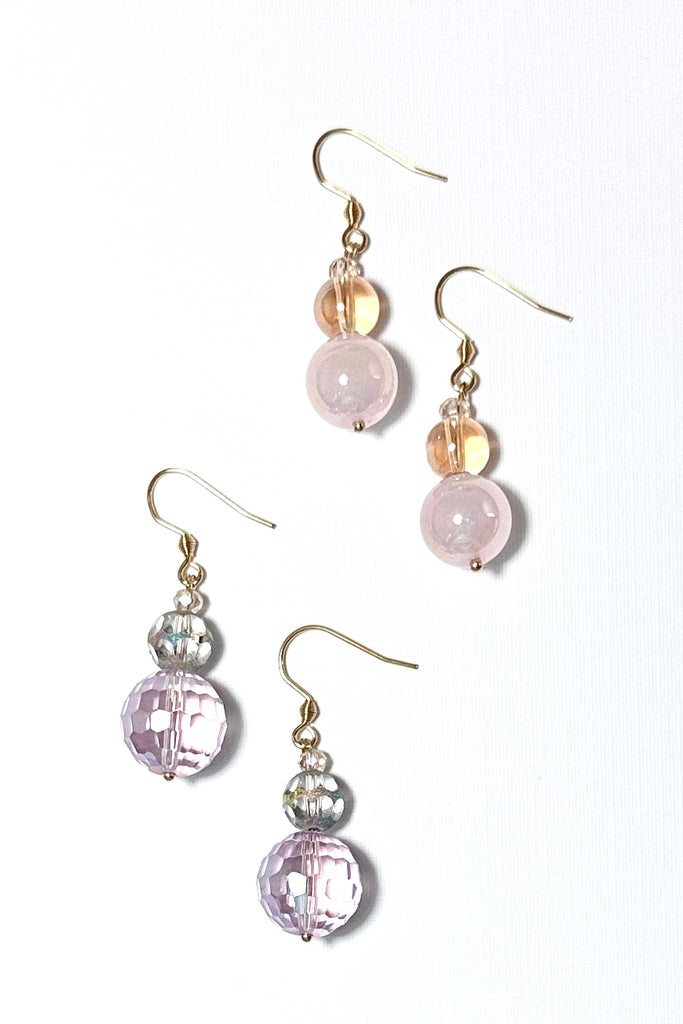 Chic earrings that are a dainty stack of sparkling crystal beads in pale pink and soft mauve, that swing from a goldtone hook. 