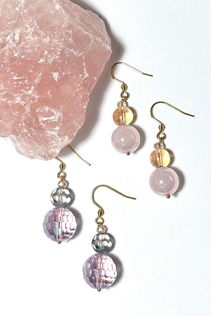 Chic earrings that are a dainty stack of sparkling crystal beads in pale pink and soft mauve, that swing from a goldtone hook. 
