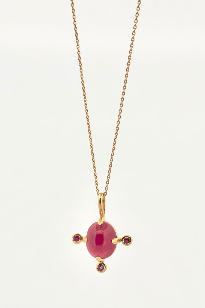 The pendant and chain are 9ct gold vermeil on a base of 925 silver, the gold is 2.5microns thick so will never rub or discolor An oval cabochon Ruby gemstone set in 9ct gold vermeil. Side stones are Sapphires. This pendant is a perfect celebration of femininity and chic. Pendant is 2.5cm long. Chain is gold vermeil