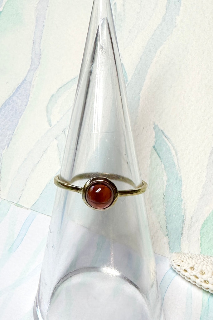 This sweet and modern ring has a rose gold vermeil finish and a simple yet intriguing feel with a garnet cabochon slightly raised from the band.