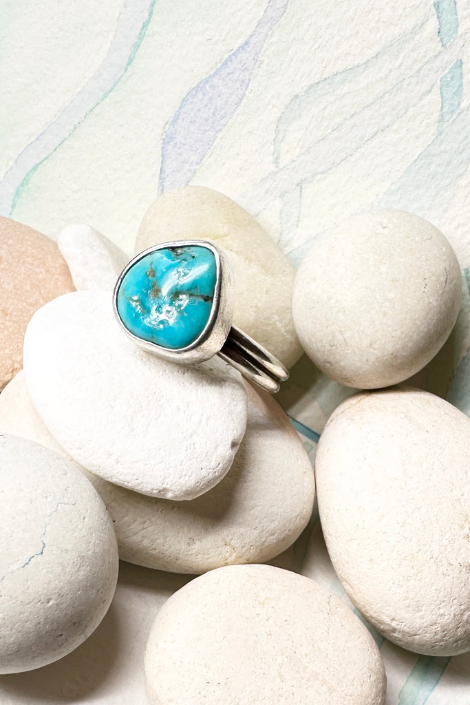 This vintage ring has a solid turquoise centre stone, it is set into a high bezel setting. The band is two rows of silver.