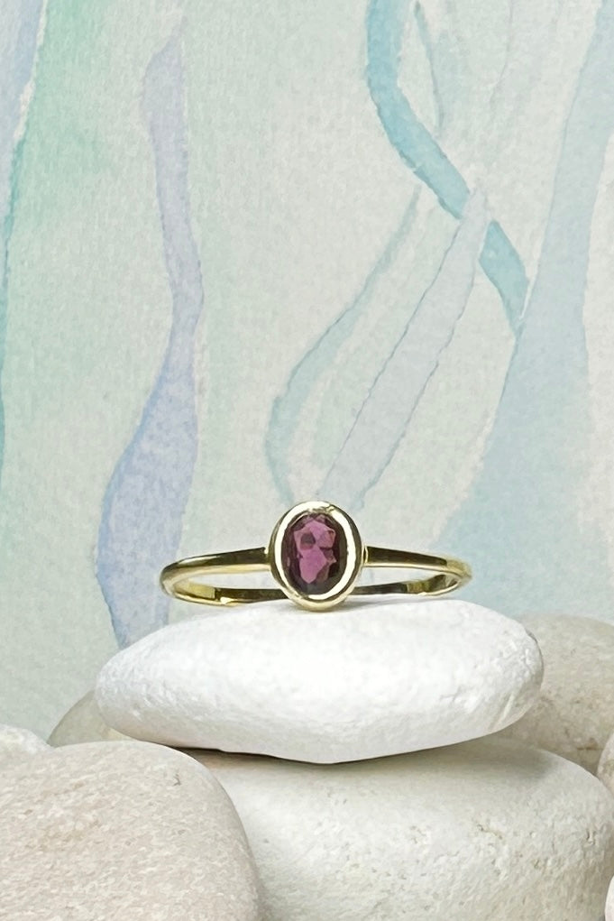 This tiny and sweet modern ring has a rose gold vermeil finish and a simple yet intriguing feel with a garnet cabochon sitting flat on the band.