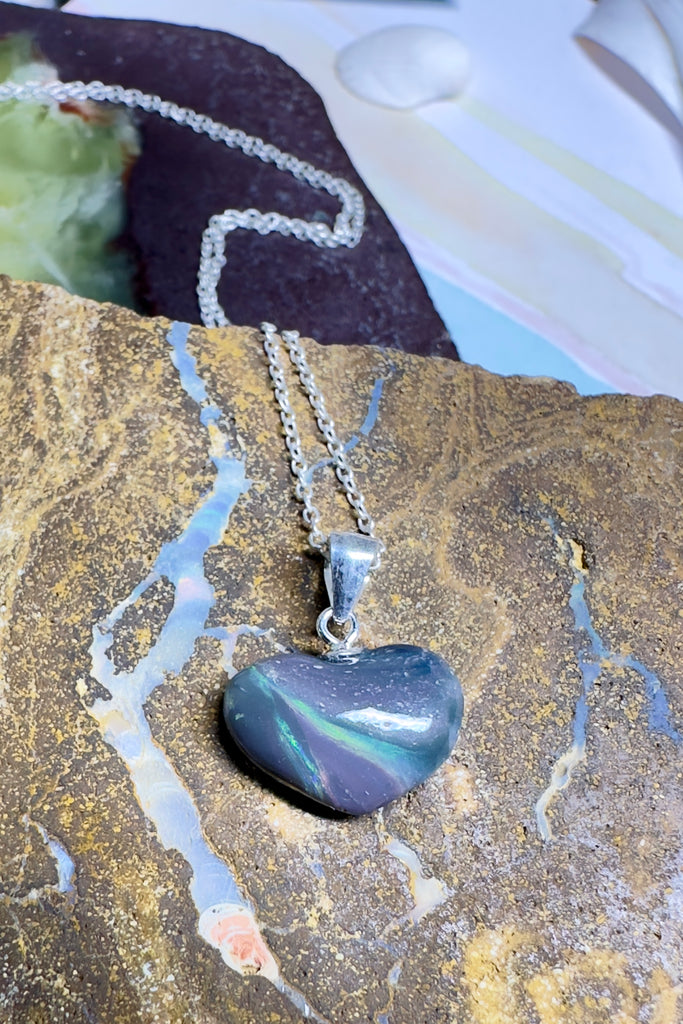This opal heart pendant is so subtle, the dark grey rock holds swirling rivers of green opal crystal in an ancient landscape.