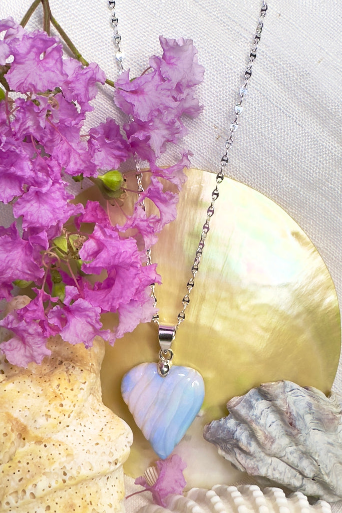 The rhythm of the sounds of the ocean swirl quietly across the face of this Opal pendant like the waves reaching a shoreline. 
