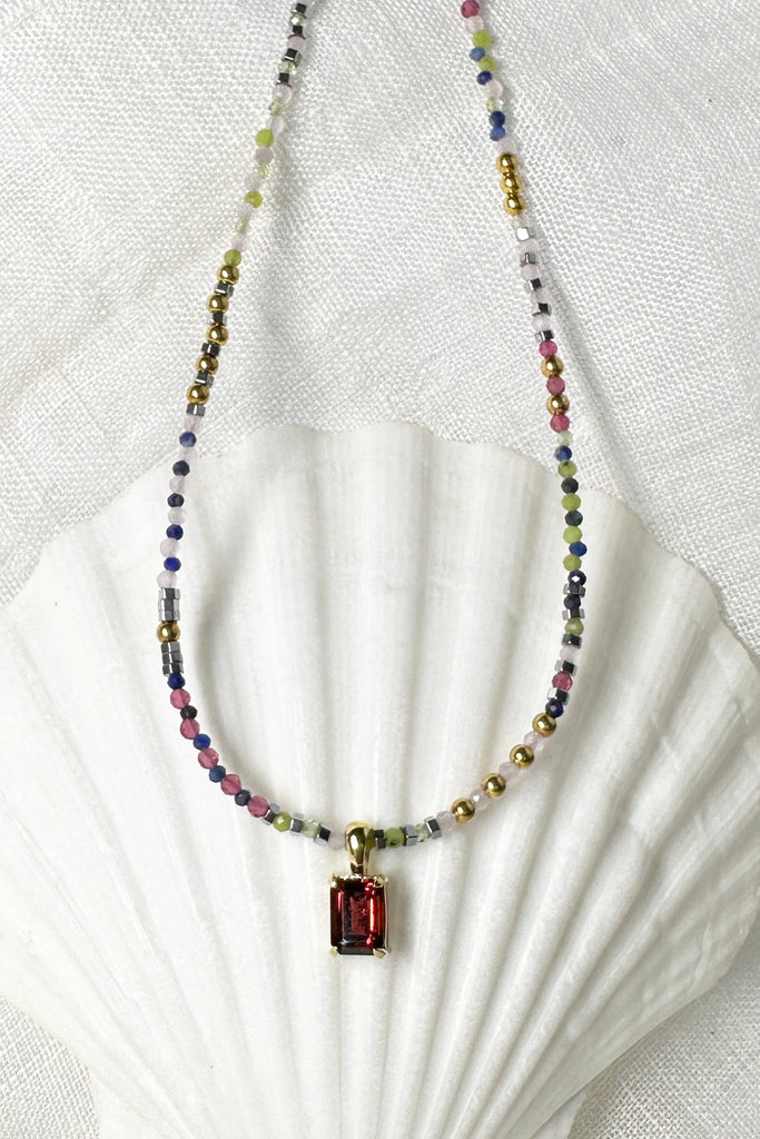 A romantic and quirky necklace, it is so modern but also romantic in style. This pretty piece has a faceted Garnet gemstone as the centrepiece.