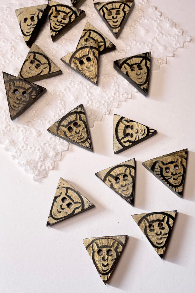These quirky little triangle buttons are carved from horn and are extremely unusual.