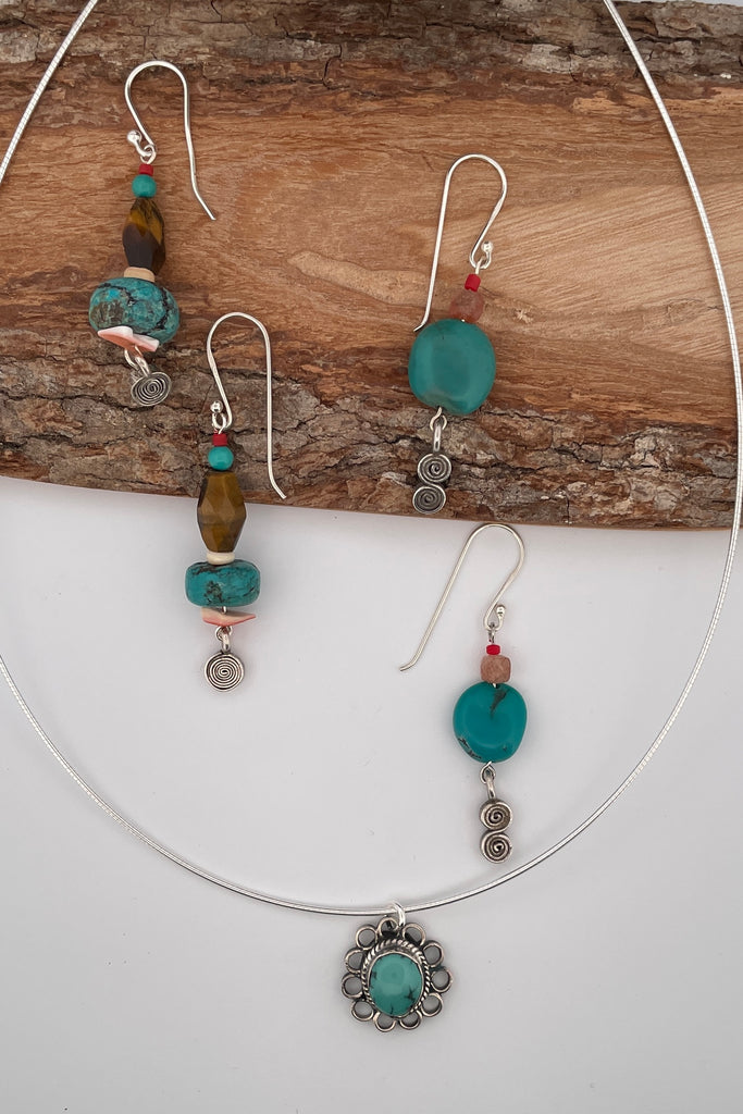 These simple handmade earrings have a strong desert vibe, the chunky natural turquoise bead is the centrepiece, with natural faceted  sunstone, and a Thai silver swing drop.