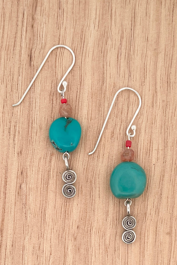 These simple handmade earrings have a strong desert vibe, the chunky natural turquoise bead is the centrepiece, with natural faceted  sunstone, and a Thai silver swing drop.