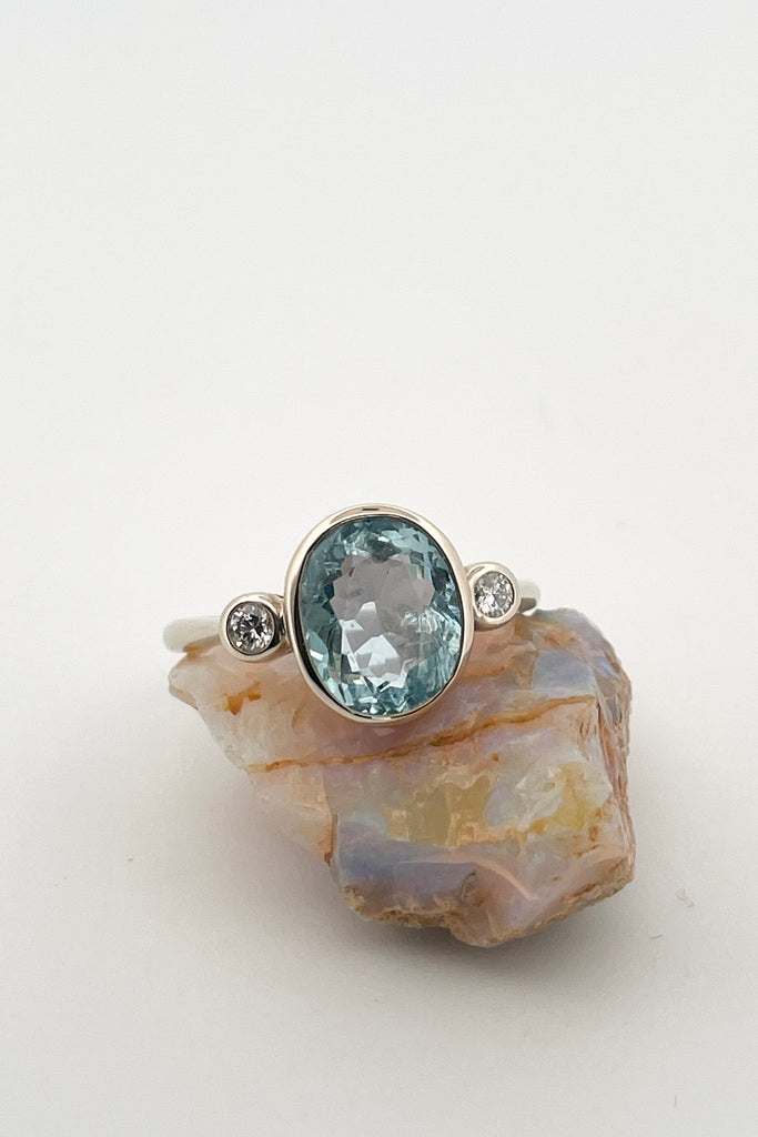 A signature designer piece. This classically styled ring holds a magnificent 10x8mm 2ct+ completely natural and unheated Mozambique Aquamarine with a sparkling 0.03ct F-G VS diamond on either side.