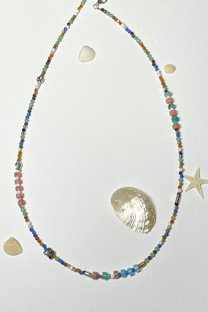 A choker style necklace made with an assortment of pretty cut, polished and faceted gemstones with silver highlight beads, this is a perfect summer beach boho style.