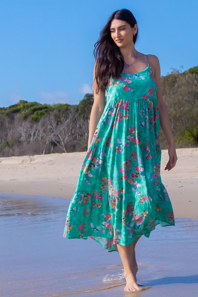 The Le Lagon Green Sea Glass Maxi Dress is a gorgeous sea green maxi dress with a green wash effect base and botanical print. The dress features silver heart beads on the shoulder straps, tiered skirting and side pockets. Made from a woven blend of cotton and rayon.