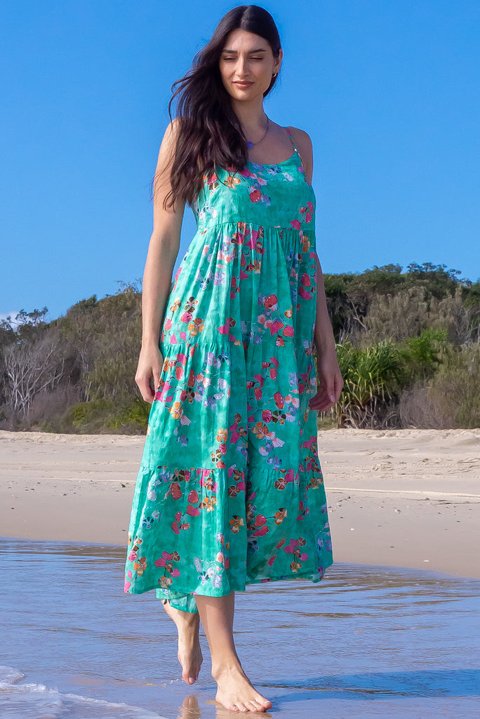 The Le Lagon Green Sea Glass Maxi Dress is a gorgeous sea green maxi dress with a green wash effect base and botanical print. The dress features silver heart beads on the shoulder straps, tiered skirting and side pockets. Made from a woven blend of cotton and rayon.
