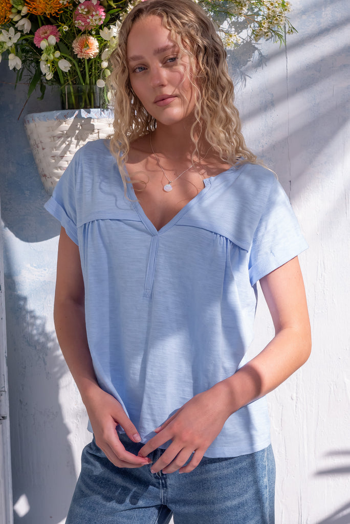 The Lei Tee Icey Cool Shirt is a beautiful ice blue t-shirt. The tee features a split neckline, rolled sleeve cuffs, and a gathered bust panel. Made from knit cotton.