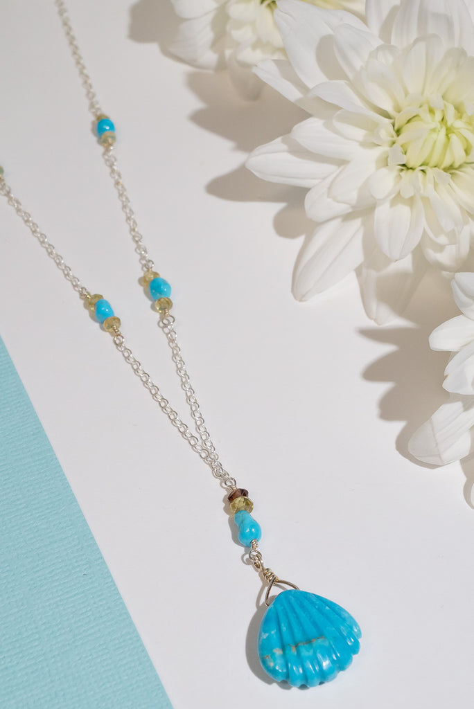 We've fallen in love with turquoise. This beautiful handmade necklace features a delicate carved turquoise scallop shell pendant.