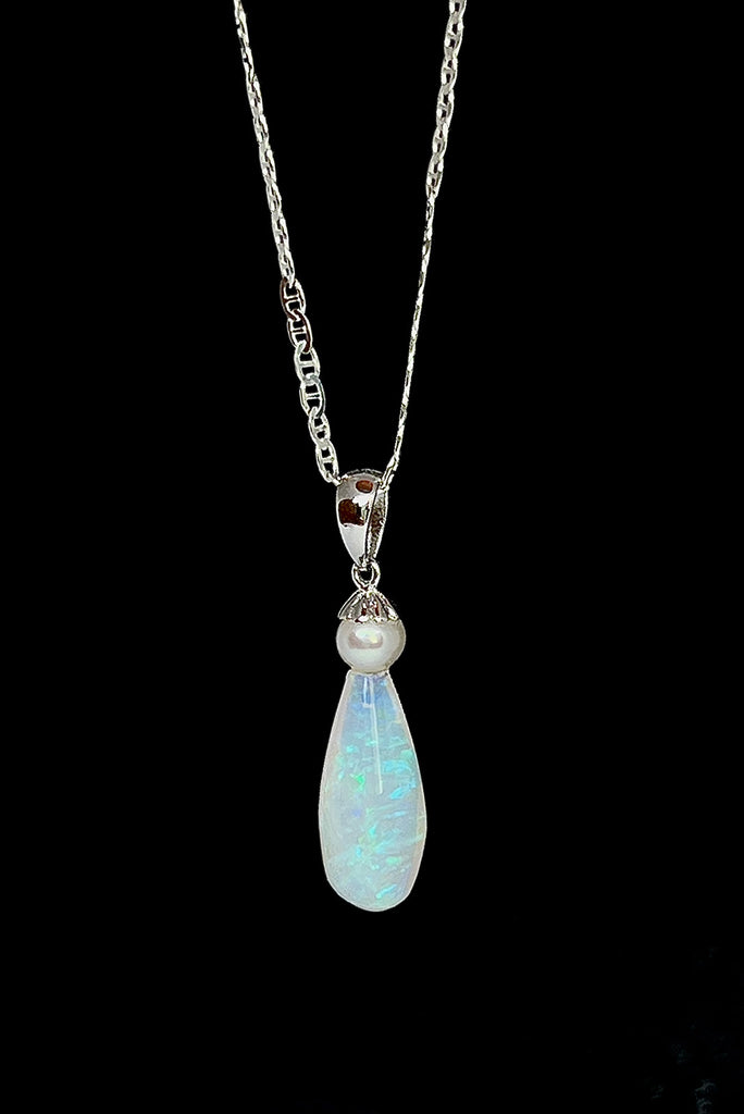 An opal pendant featuring a droplet of Australian crystal opal cut and polished to reveal the flecks of colour through the stone. A one of a kind opal. This piece has soft mystical colouring, flecks of green, blue and mauve.