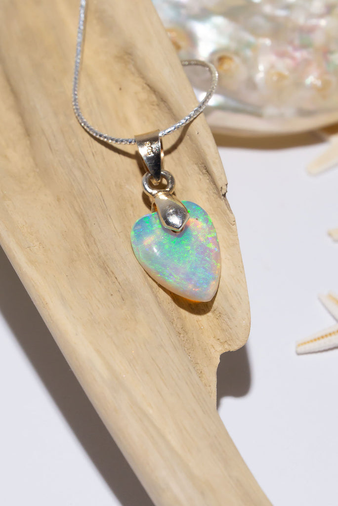A delicate crystal opal pendant, it has feathery green and a little pink coloration, as soft and pretty as a feather in the wind.