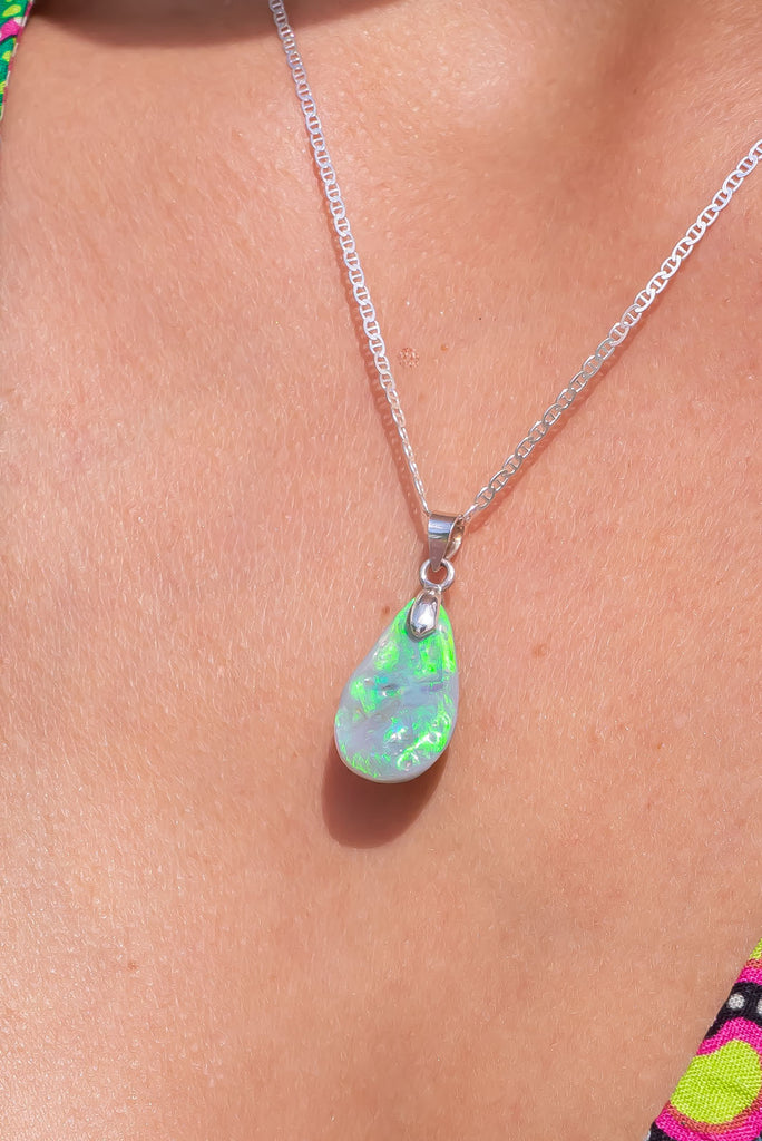 An organic natural piece with a softly undulating surface, it has incredible bright green flashes across the surface. This stone is a semi black from Lightening Ridge.