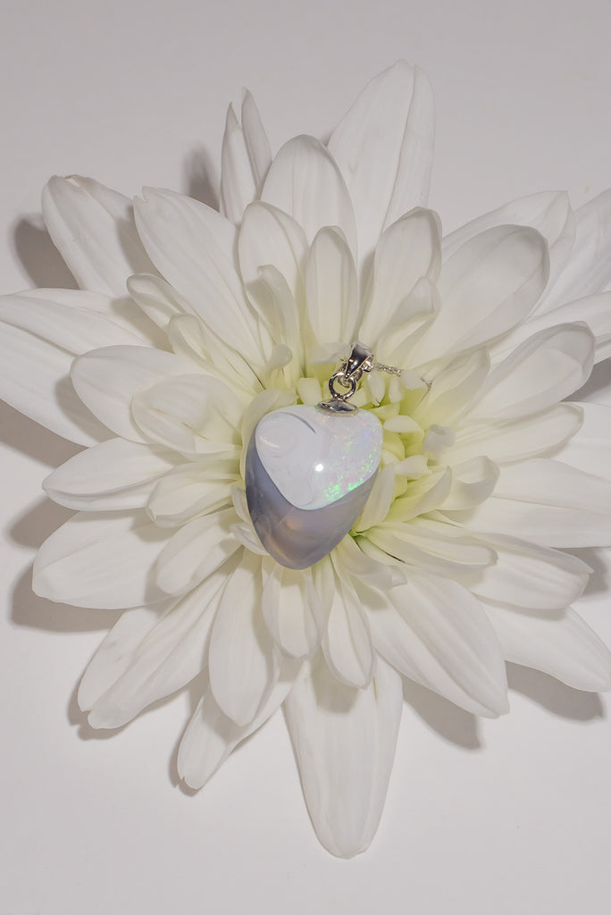 A totally unique opal pendant, when examining the stone our cutter found a perfect heart with a perfect shadow of crystal opal. The white at the top is sprinkled with tiny pink and green sparkle, this opal has a mystery all of its own.