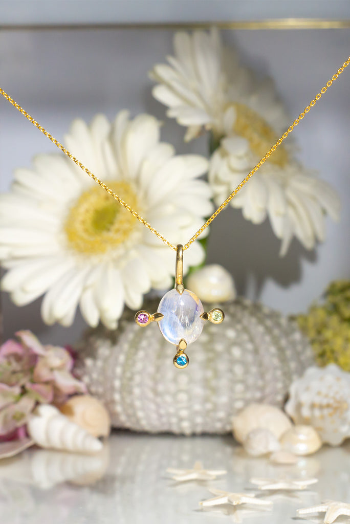 The pendant and chain are 9ct gold vermeil on a base of 925 silver, the gold is 2.5microns thick so will never rub or discolor An oval cabochon cut top quality Moonstone gemstone set in 9ct gold vermeil. Side stones are Sapphires.