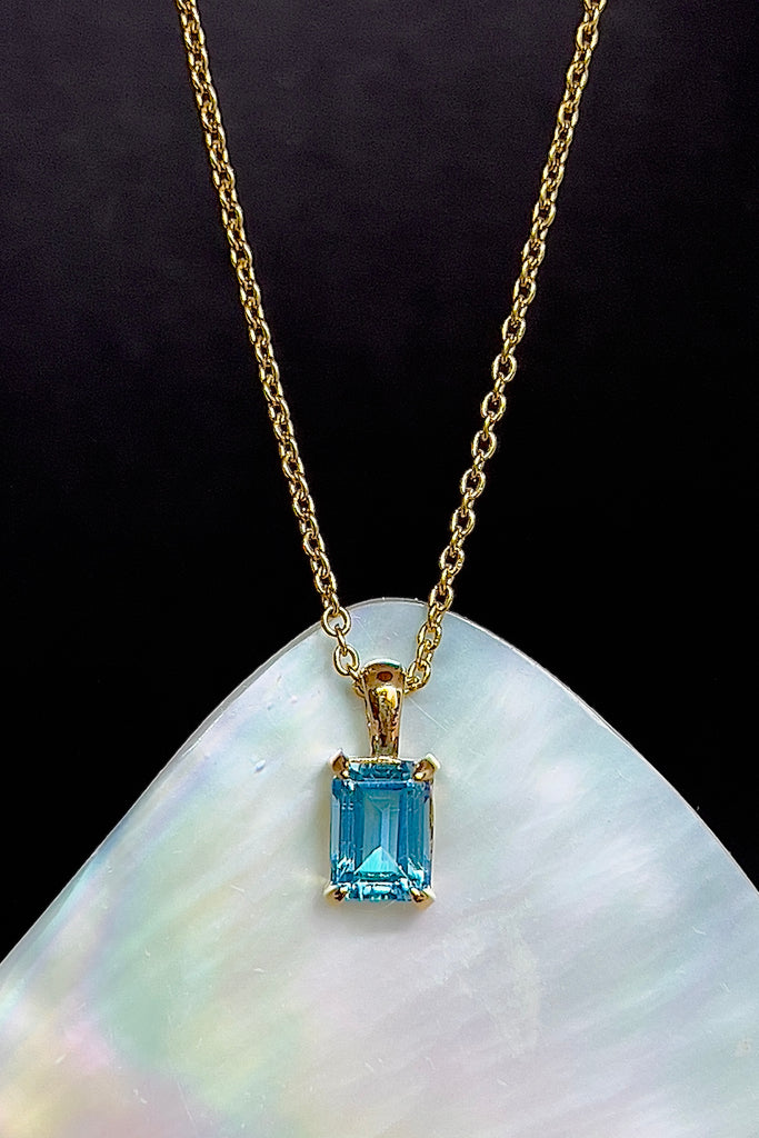 The pendant and chain are 9ct gold vermeil on a base of 925 silver, the gold is 2.5microns thick so will never rub or discolor An emerald cut Blue Topaz gemstone set in 9ct gold vermeil. Swiss blue Topaz gemstone. Pendant is 4cm long. Chain is gold vermeil