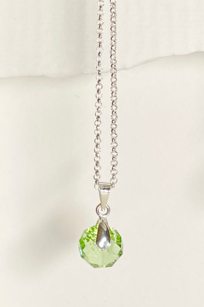 A dainty crystal bead hung from a silvery bail. 