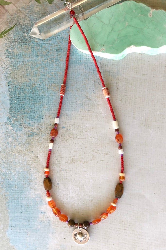 Necklace Cay Silver Circle has beads featuring Carnelian, shell, wood and Turkish glass beads and hill tribe silver centre piece with circle detail.