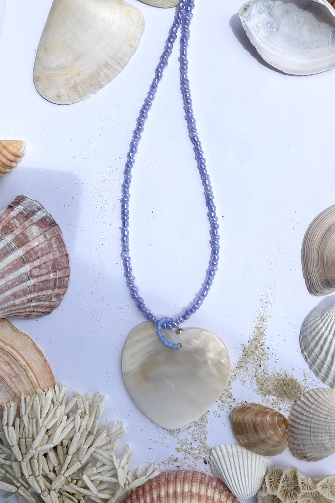 heart is hand carved from Mother of Pearl shell, each heart carries the distinctive marks of the artist who created it, no two shells are ever alike,  strung on pearlescent pale mauve glass beads.