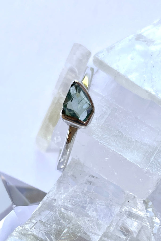 This natural tourmaline has been cut in an elegant free form geometric style, then set to fit its unique lines and brilliant colours creating a one of a kind piece.