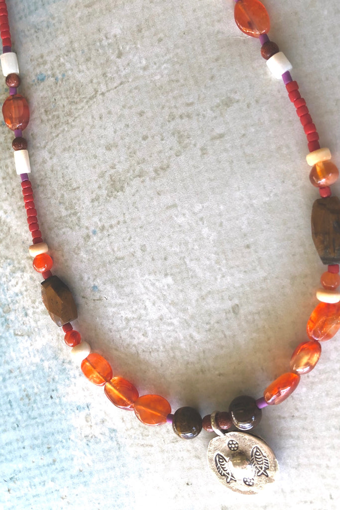 Necklace Cay Silver Circle has beads featuring Carnelian, shell, wood and Turkish glass beads and hill tribe silver centre piece with circle detail.