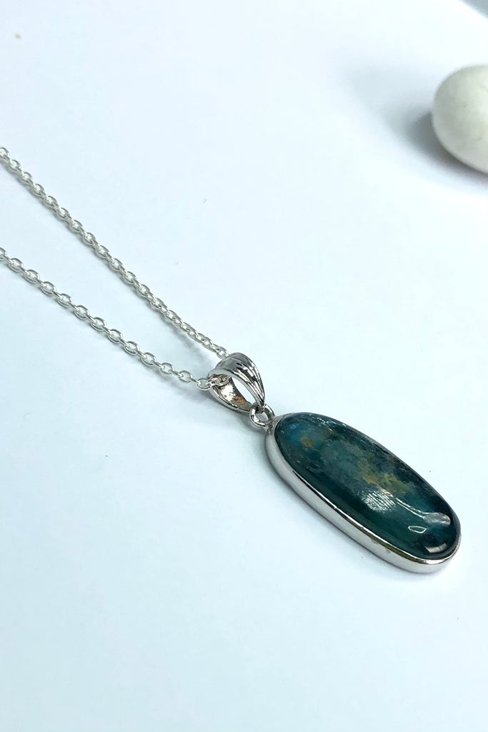 this stone is a greenish grey blue with silvery flashes. It is blue green when held to the light, showing some inclusions on the table, 
