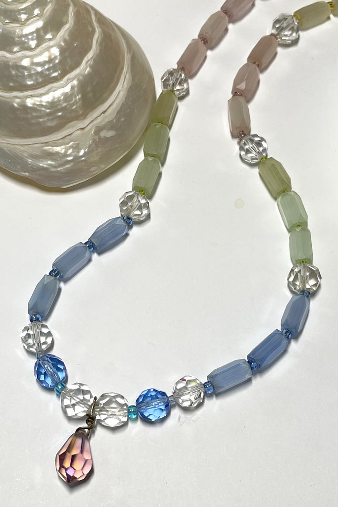 This beautiful necklace is made with vintage crystal beads in clear and a lovely faceted clear blue colour, and also has old Venetian glass beads in pale green pink and yellow. It also has a central pinky mauve droplet bead.