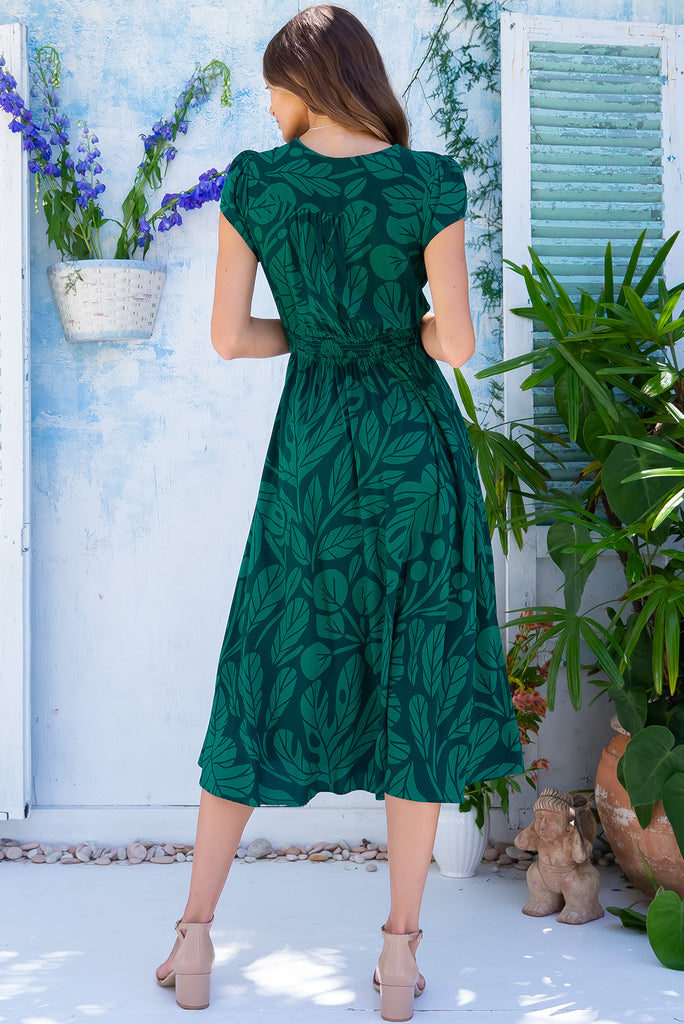 The Lizzie Botany Green Midi Dress is a gorgeous dark green based midi dress with a deep green botanical leaf print. The dress features cap sleeves, a deep v neckline, fitted basque waist with gathered bust, elastic shirring at back waist, side pockets and is made from woven 100% rayon.