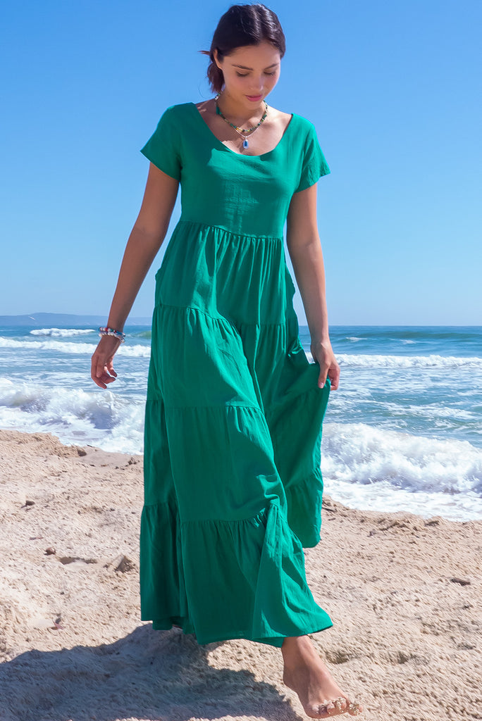The Lucky Lulu Jade Tiered Maxi Dress is a gorgeous jade green maxi dress. This dress features a scooped neckline, adjustable waist tabs, side pockets and a wide tiered skirt. Made from woven 100% cotton.