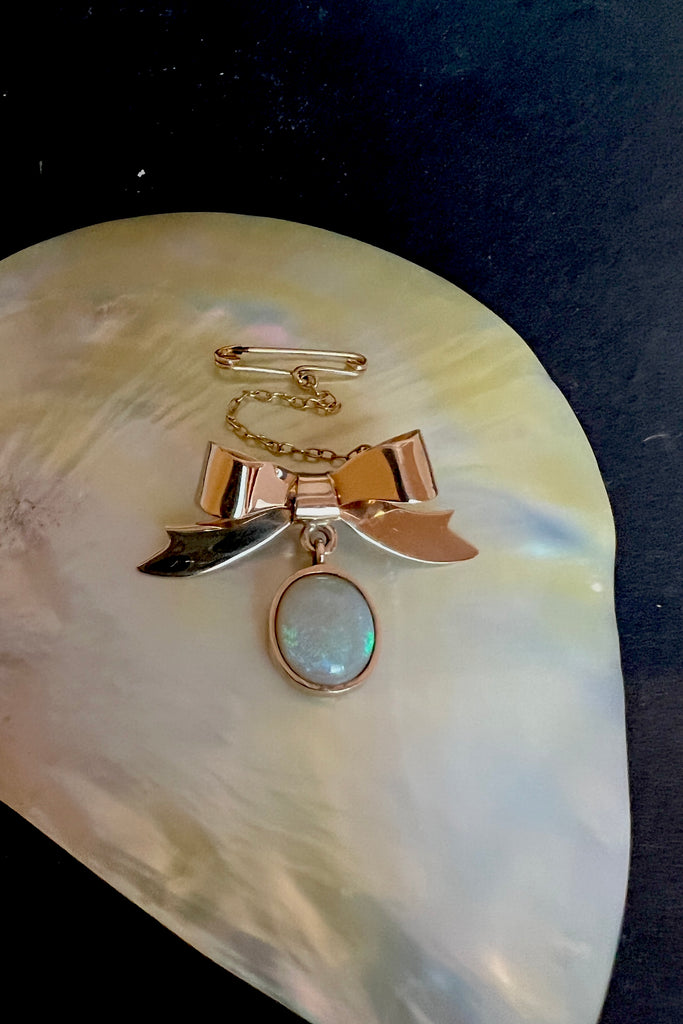 This Vintage Solid Opal and 9ct Gold Bow Brooch is just too sweet! The pretty little gold bow neatly holds the drop of Opal. This interesting pre-loved piece is in very good condition.