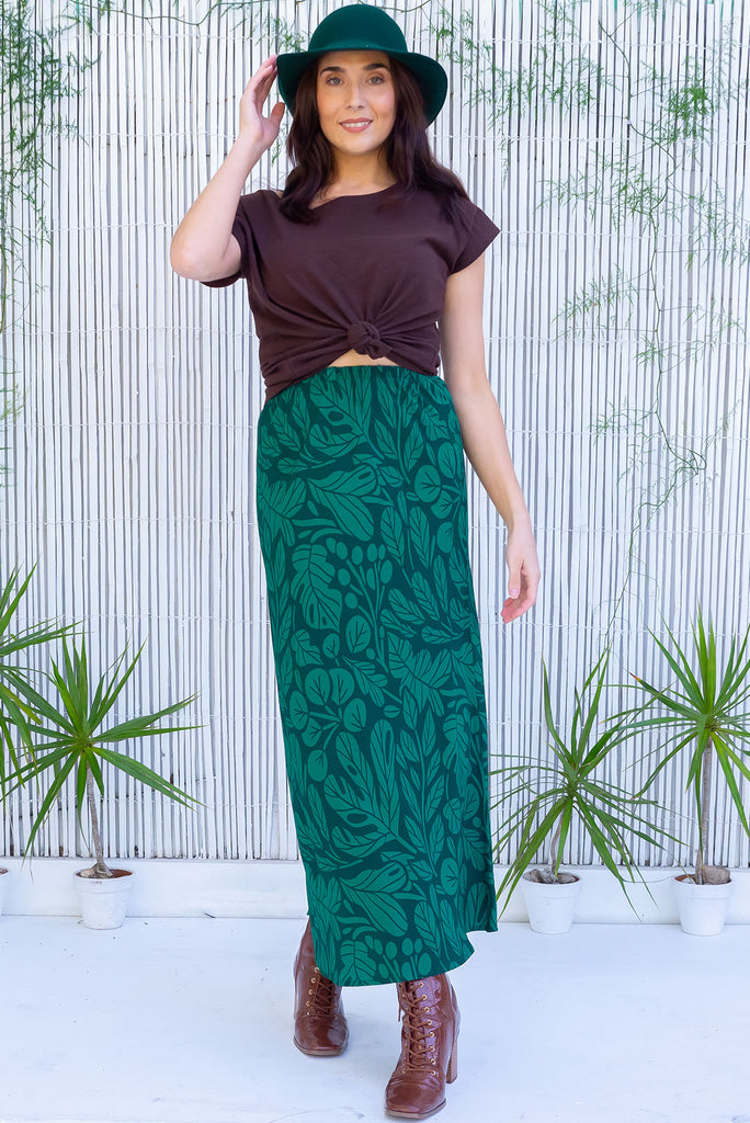 The Bianca Botany Bias Cut Maxi Skirt is a tonal green maxi skirt with a botanical silhouette print. The skirt features a bias cut, elasticated waist and belt loop with removable waist tie pocket. Made from 100% rayon.