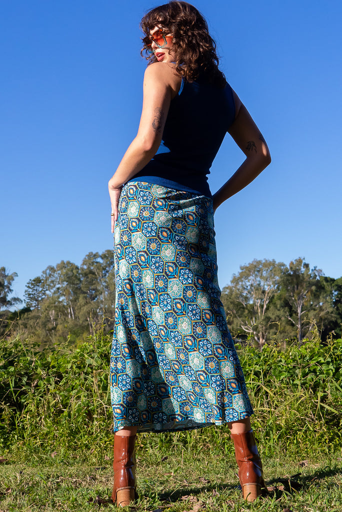 The Bianca Toledo Bias Cut Maxi Skirt is a beautiful blue skirt with a hexagonal Mexican tile print. The skirt features a bias cut, elasticated waist and belt loop with removable waist tie pocket. Made from 100% rayon.