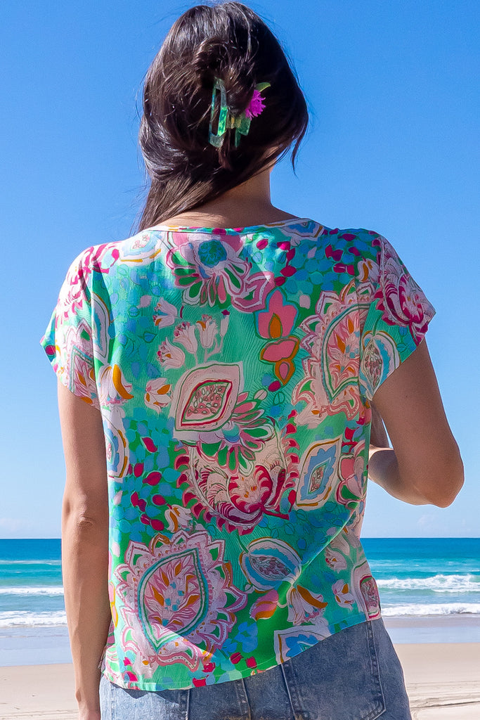 The Day Tripper Green Leaf Top is a gorgeous green t-shirt with a large, abstract leaf print. The top features a scooped neckline, lace insert across the chest, cap sleeves, and a amall split in the side seams. Made from woven rayon.