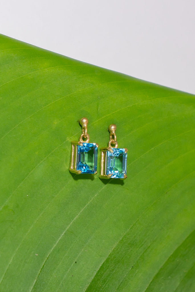 These pretty ocean coloured blue Topaz earrings are a perfect droplet of sea and sky. Pretty earrings with an emerald cut Blue Topaz gemstone set in 9ct gold vermeil. Made exclusively for Mombasa Rose Boutique.