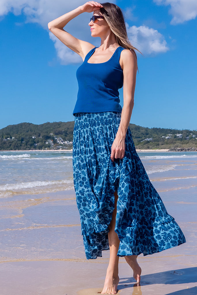 The Echo Blue Palms Maxi Skirt is a beautiful blue maxi skirt with a dark blue leaf silhouette  print. The skirt features an elasticated waistband, tiering and side pockets. Made from crinkle rayon.