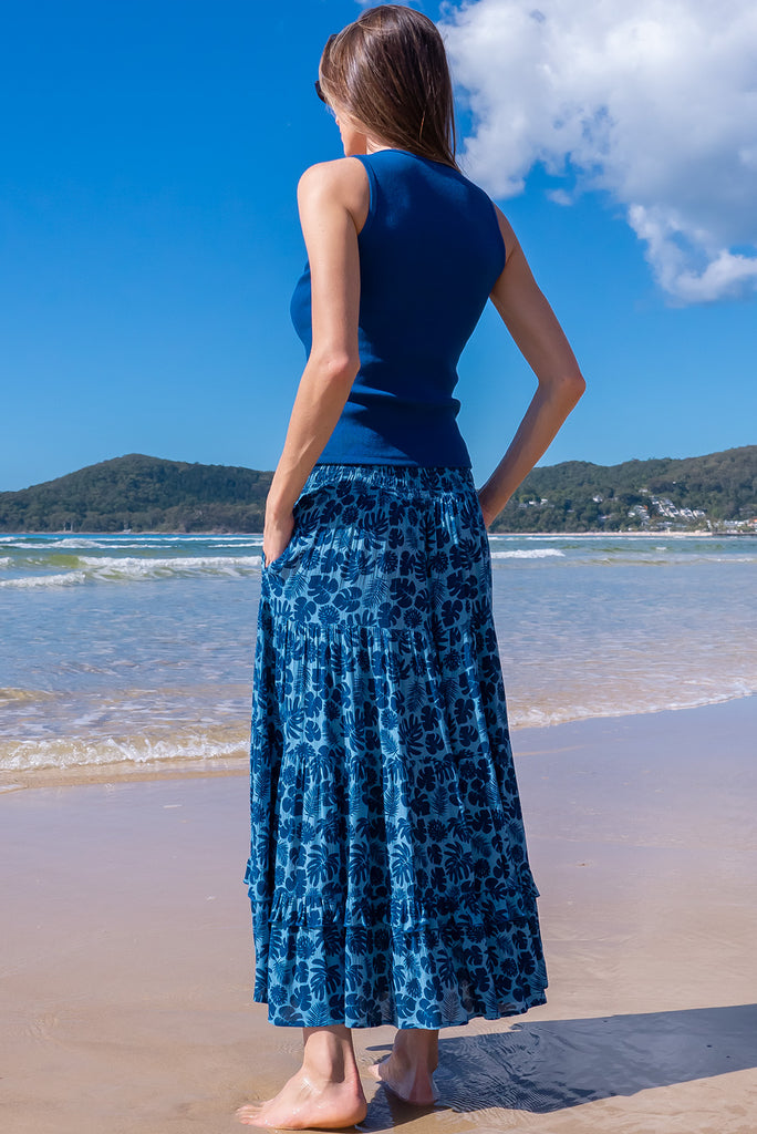 The Echo Blue Palms Maxi Skirt is a beautiful blue maxi skirt with a dark blue leaf silhouette  print. The skirt features an elasticated waistband, tiering and side pockets. Made from crinkle rayon.