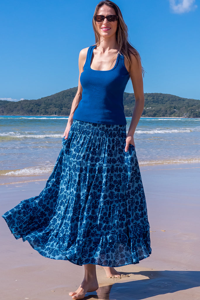 The Echo Blue Palms Maxi Skirt is a beautiful blue maxi skirt with a dark blue leaf silhouette  print. The skirt features an elasticated waistband, tiering and side pockets. Made from crinkle rayon.