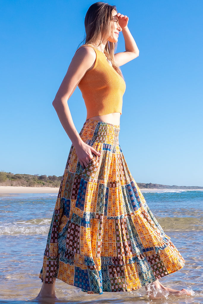 The Astro Mango Knit Tank Top is a luxurious orange tank top. The tank top features a high neck, stretchy knit fabric, ribbed texture and is fitted. 