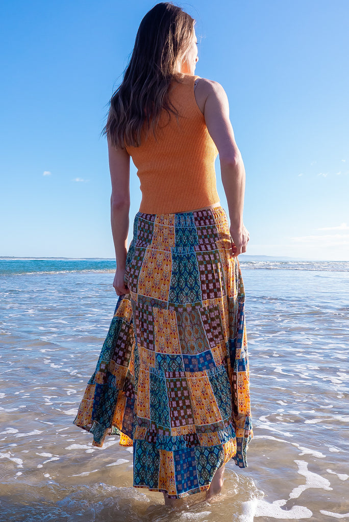 The Echo Golden Patch Maxi Skirt is a gorgeous maxi skirt with a bohemian style patchwork print in golden and blue tones. The skirt features an elasticated waistband, tiering and side pockets. Made from crinkle rayon.