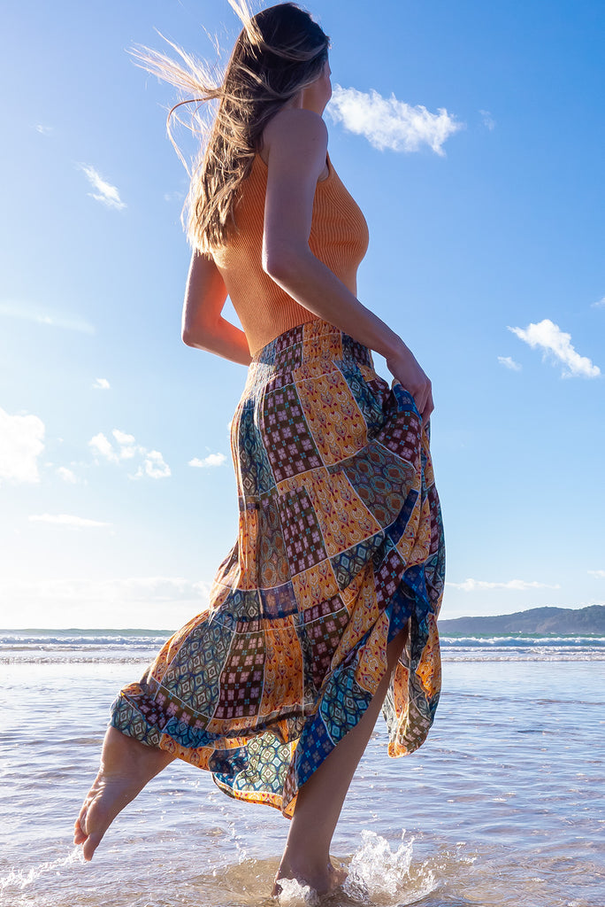 The Echo Golden Patch Maxi Skirt is a gorgeous maxi skirt with a bohemian style patchwork print in golden and blue tones. The skirt features an elasticated waistband, tiering and side pockets. Made from crinkle rayon.