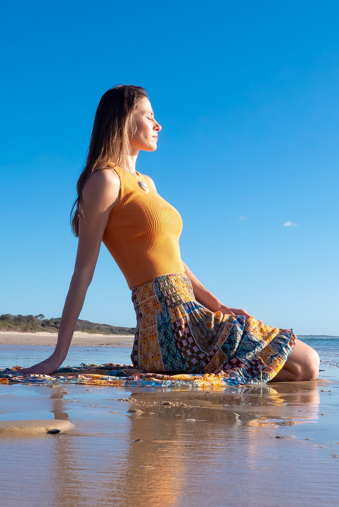 The Astro Mango Knit Tank Top is a luxurious orange tank top. The tank top features a high neck, stretchy knit fabric, ribbed texture and is fitted. 