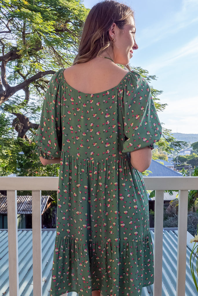 The Emelia Green Flowers Short Dress is a gorgeous green mini dress with a small white and pink floral print. The mini dress features 3/4 sleeves with elastic cuffs, tiered skirting and side pockets. Made from a woven blend of crinkle rayon.
