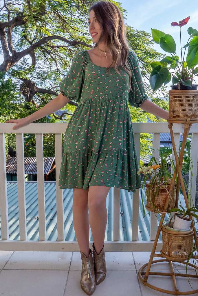 The Emelia Green Flowers Short Dress is a gorgeous green mini dress with a small white and pink floral print. The mini dress features 3/4 sleeves with elastic cuffs, tiered skirting and side pockets. Made from a woven blend of crinkle rayon.